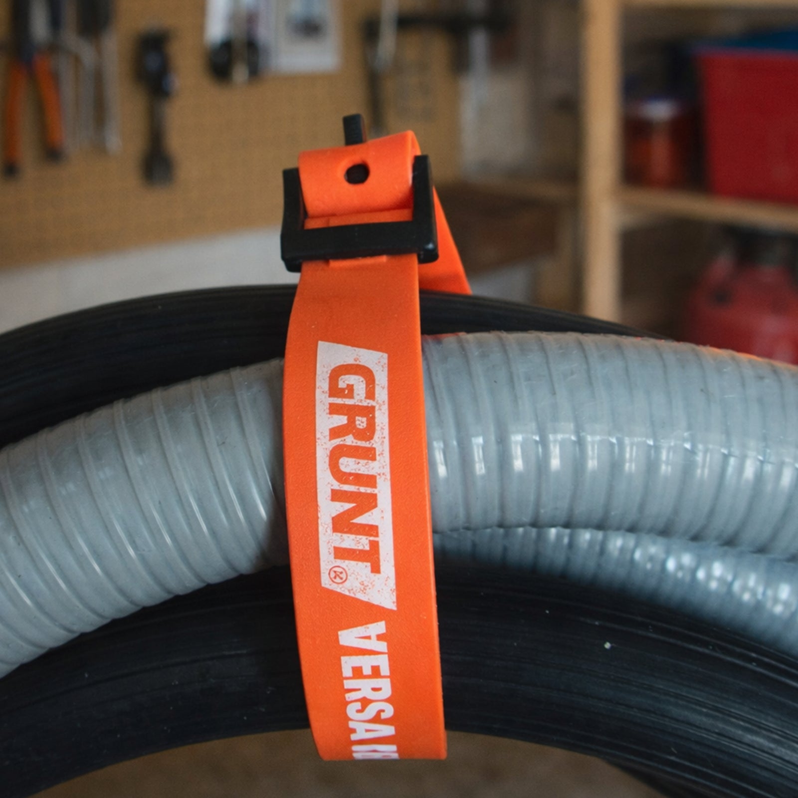GRUNT 20mm x 40cm Black and Orange Versa Strap – compact multi-purpose securing strap for organising cables, tools, and gear. Reusable hook-and-loop design for quick attach and release. Available at Bunnings AU and NZ.