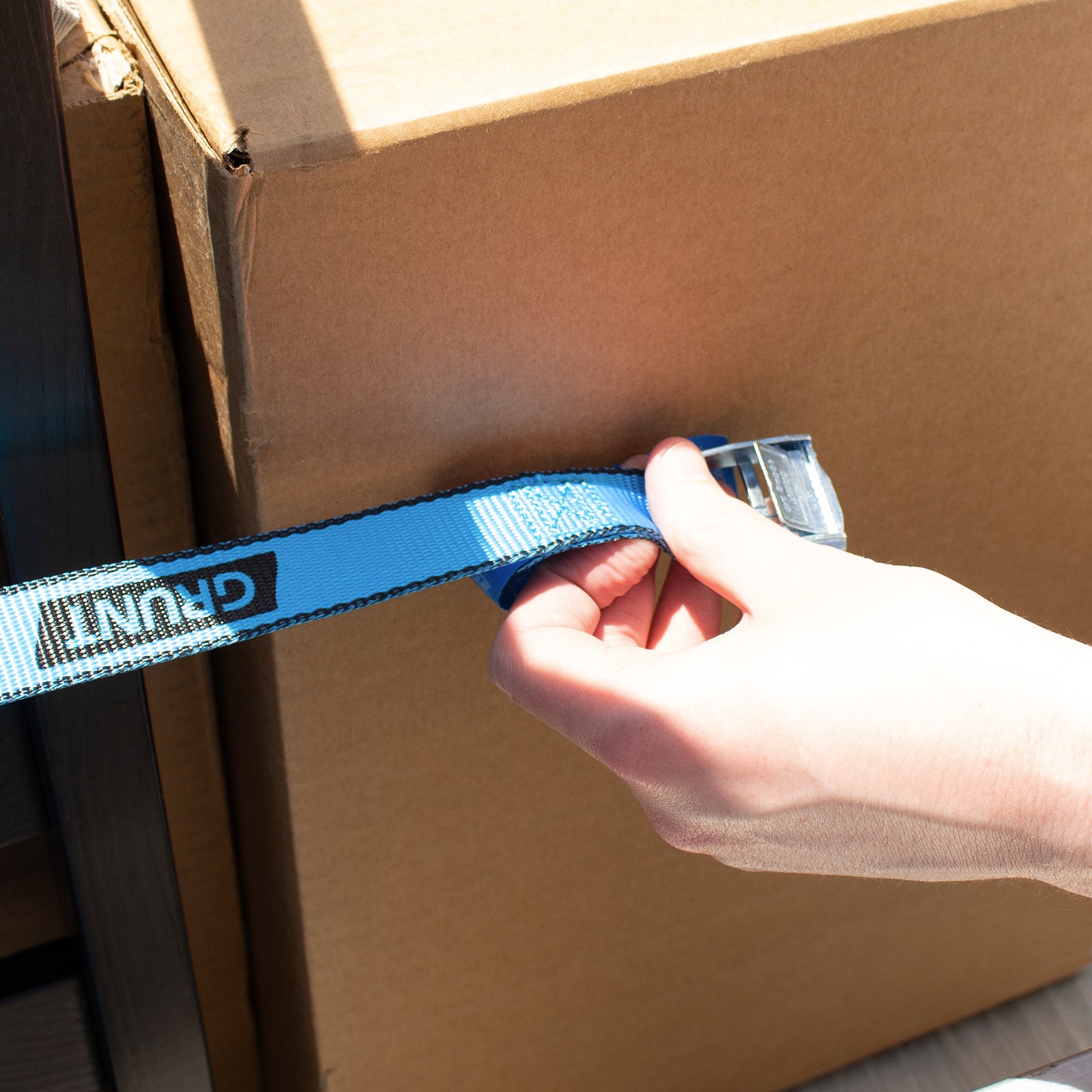GRUNT 25mm x 2m Blue Pull Tie Down Strap – cam-buckle pull strap for securing light loads, motorcycles, and sports equipment. Quick and easy pull-to-lock mechanism. Available at Bunnings AU and NZ.