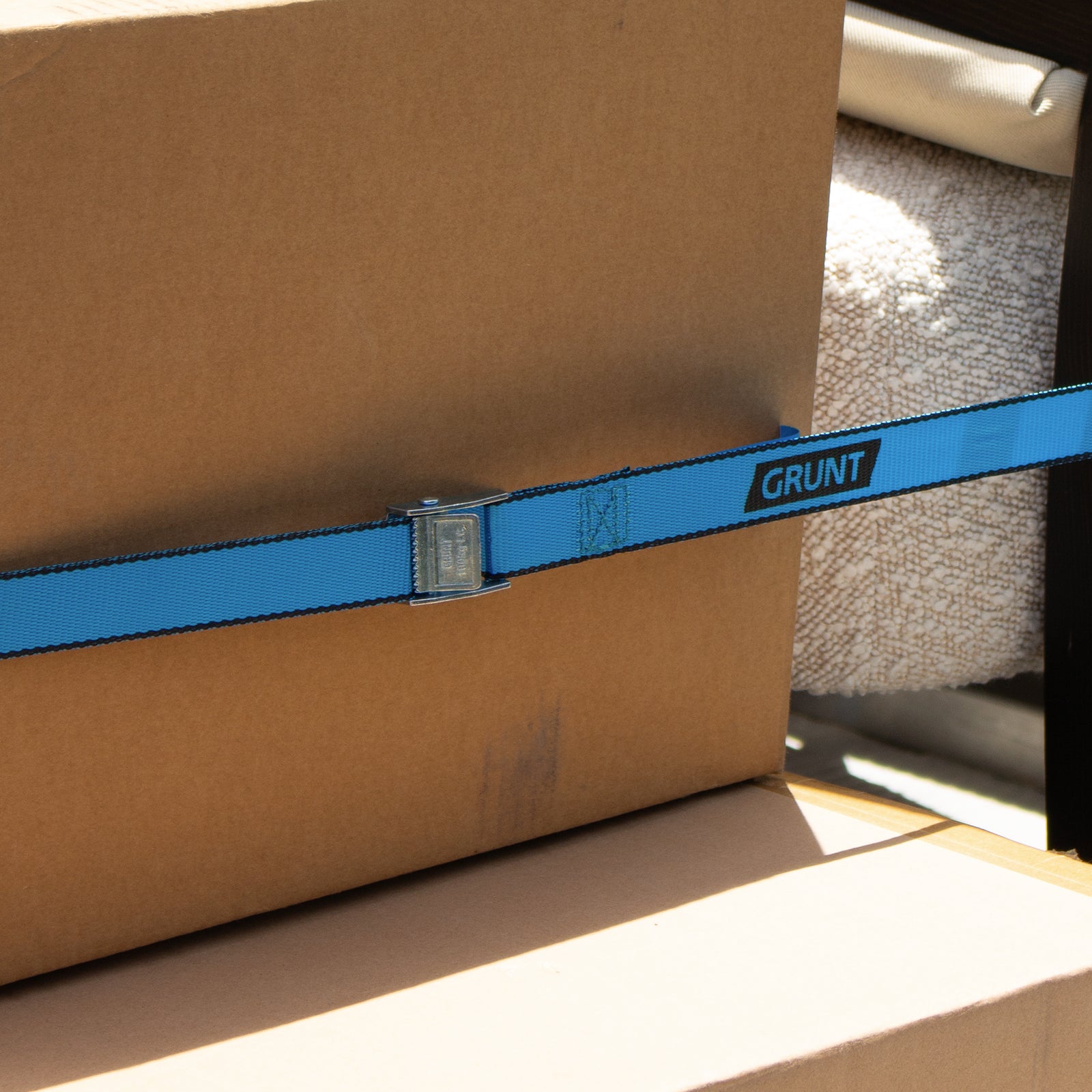 GRUNT 25mm x 2m Blue Pull Tie Down Strap – cam-buckle pull strap for securing light loads, motorcycles, and sports equipment. Quick and easy pull-to-lock mechanism. Available at Bunnings AU and NZ.