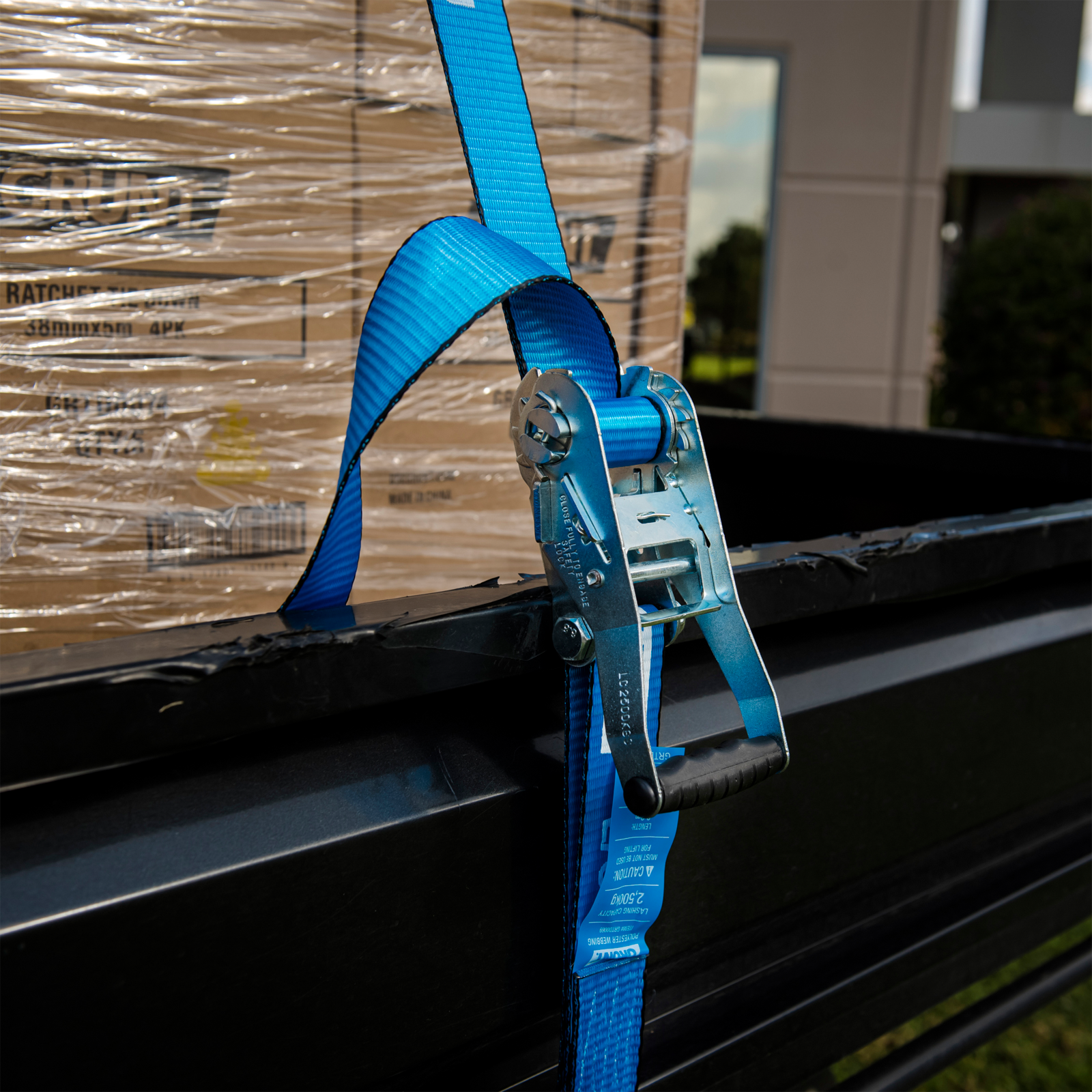 GRUNT 50mm x 9m Blue and Yellow Heavy Duty Ratchet Tie Down – long-reach extra-wide ratchet strap for securing heavy machinery, furniture, and large loads on trailers and trucks. Available at Bunnings AU and NZ.
